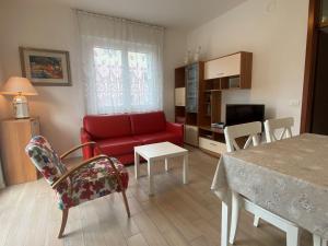 sala de estar con sofá rojo y mesa en Casa Belli Holiday Apartments Adults Only, en Arco