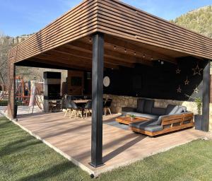 a pavilion with a couch on a wooden deck at Casa rural Los Pilares de la Sierra in Arahuetes