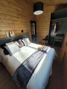 een slaapkamer met een groot bed en een houten muur bij Casa rural Los Pilares de la Sierra in Arahuetes