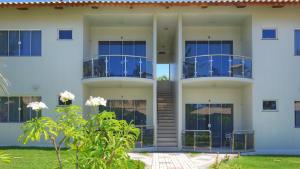 un edificio blanco con balcones azules en Pousada Kalunga, en Flecheiras