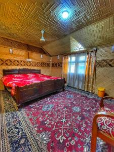 a bedroom with a large bed and a red carpet at Pasadona Floating Houseboat in Srinagar