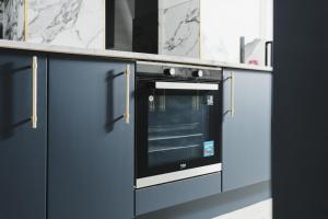 a kitchen with blue cabinets and an oven at Captivating 2-Bed Apartment in Liverpool in Liverpool