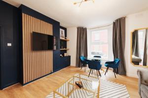 a living room with a table and blue chairs at Captivating 2-Bed Apartment in Liverpool in Liverpool