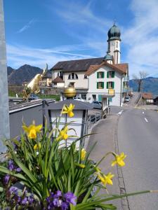 a house with a lighthouse on a street with flowers at Hotel Tell in Seelisberg