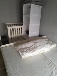 a white bed with a crib in a room at Stacaravan 14 met airco vakantiepark de Tien Heugten Schoonloo Drenthe in Schoonloo