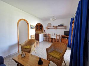 un soggiorno con tavolo e sedie e una cucina di Apartamento Primera Linea de Playa Son Bou ad Alaior