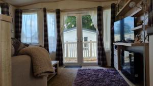 a living room with a sliding glass door at Stunning 2 Bed Static Caravan at Hoburne Devon Bay in Goodrington