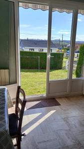 una puerta corredera de cristal abierta con vistas a un patio en Gîte paisible, 