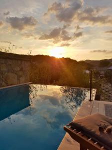 a swimming pool with the sunset in the background at Felix Pension in Băile Govora