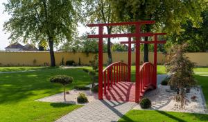 una puerta roja en medio de un jardín en EPRESPARK Panzió en Vecsés