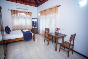 a bedroom with a bed and a table and chairs at Villa Sun Grace in Galle