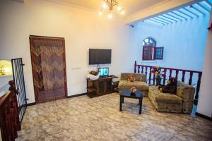 a living room with a couch and a tv at Villa Sun Grace in Galle