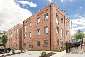 a brick building with a car parked in front of it at Wakefield City Centre 1 minute walk to station 2 bedroom townhouse with parking in Wakefield