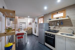 a kitchen with a refrigerator and a sink and a table at Villa Gaudì - Mallorca in Sant'Isidoro