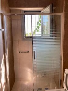 La salle de bains est pourvue d'une douche avec une porte en verre. dans l'établissement Villa theosis, à Nikiana