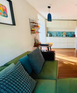 a living room with a green couch and a kitchen at The Hideaway Apartment, Bath in Bath