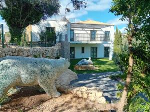 a statue of a bear in front of a house at Carvoeiro Gardens in Carvoeiro