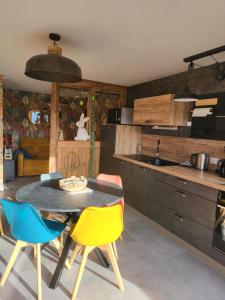 una cocina con mesa y algunas sillas. en Le cocon du rondeau(gîte cosy), en Labergement-Sainte-Marie