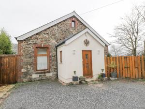 a brick and stone house with a wooden fence at The Old Sunday School in Gunnislake