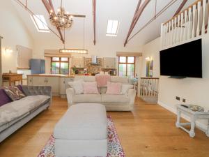 a living room with two couches and a flat screen tv at The Old Sunday School in Gunnislake