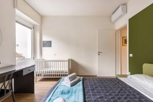 a bedroom with a bed and a desk and a crib at Valeria Apartment in Bardolino