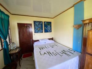 a bedroom with a bed with the words welcomeianeiane at Santa Claus Hilltop in San Vicente