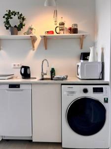 a kitchen with a washing machine and a sink at Selfoss Center apartment in Selfoss