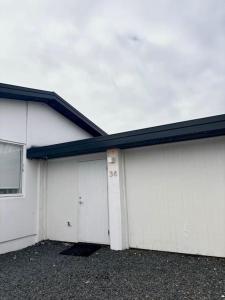 a row of four white garage doors on a building at Selfoss Center apartment in Selfoss