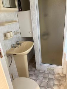 uma casa de banho com um chuveiro, um lavatório e um WC. em Stacaravan 426 met airco vakantiepark de Tien Heugten Schoonloo Drenthe em Schoonloo