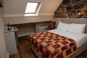 a bedroom with a bed and a brick wall at Donegal House in Donegal
