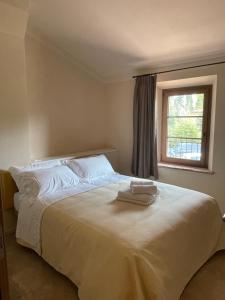 a bedroom with a large white bed with a window at Tenuta i 4 venti in Collesalvetti