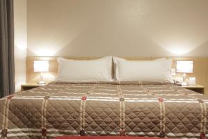เตียงในห้องที่ Castelo Inn Hotel