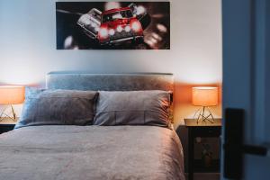 a bedroom with a bed with a car picture on the wall at No.10 Bristol in Bristol