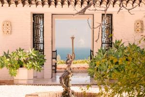 una statua davanti a una porta con vista sull'oceano di Quinta La Colina - Rancho Domingo a Benalmádena