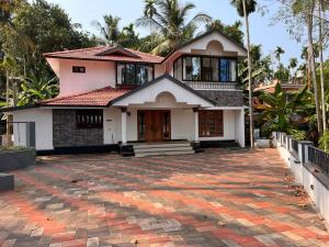 a house with a brick driveway in front of it at Manasam Homes Near To IIM & NIT - kOZHIKODE in Kunnamangalam