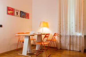 サン・ピエーロ・ア・シエーヴェにあるLa Stazione Per Dormire Guest Houseのテーブル、椅子、ランプが備わるお部屋