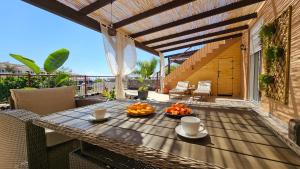 a table with two cups and oranges on a patio at Coastal Dream Villa in San Miguel de Abona