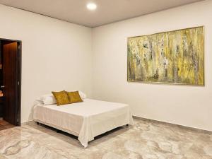 ein Schlafzimmer mit einem Bett und einem Wandgemälde in der Unterkunft M12. Casa Moai Casa grande ubicado a 5 min de San Antonio. in Cali