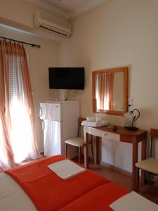 um quarto com uma cama e uma secretária com um espelho em Efstratios Hotel em Loutra Edipsou