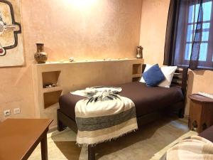 a bedroom with a bed and a table and a window at Dar Latigeo in Essaouira +36 photos