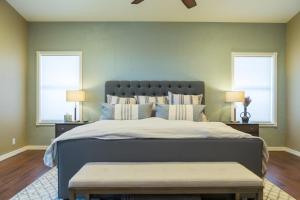 a bedroom with a large bed with two windows at Desert Paradise Pool Spa Pickleball Putt Green in Phoenix