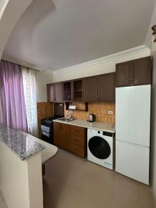 a kitchen with brown cabinets and a white refrigerator at your home in Batumi in Batumi