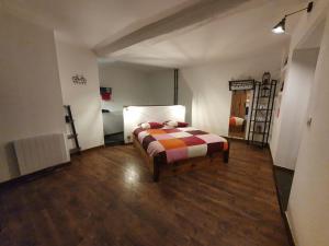 1 dormitorio con 1 cama en una habitación con suelo de madera en Maison de campagne, en Amponville