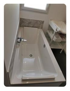 El baño incluye bañera blanca con lavamanos. en Biard en Charvonnex