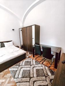 una camera con un letto e due sedie e un tappeto di Studio Berindei a Cluj-Napoca