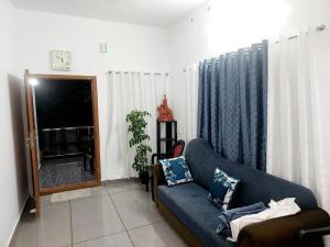 a living room with a couch and a tv at Alleppy Whitefort Homestay Dulux Rooms -HouseBoat Available in Alleppey