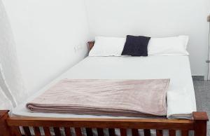 łóżko z białą pościelą i poduszkami w obiekcie Alleppy Whitefort Homestay Dulux Rooms with Balcony w mieście Alappuzha