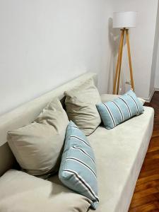 un sofá con 3 almohadas en una habitación en Buenos Aires Apartamento ADDA en Buenos Aires