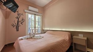 uma cama num quarto com uma janela em Hotel El Libertador em La Falda
