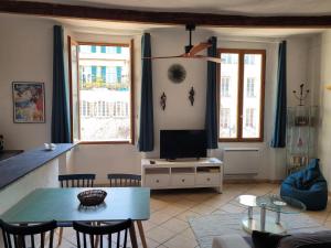 a living room with a table and a tv at LA GRENILLE in Antibes